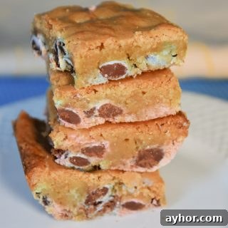 Easter Blondie Bars with Marshmallow Eggs Recipe 13 Stack of chocolate chip Easter blondies on a white plate.