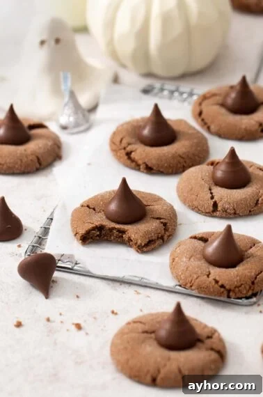 Gluten-free Nutella witch hat cookies on a wire cooling rack. One cookie has a bite taken out of it.