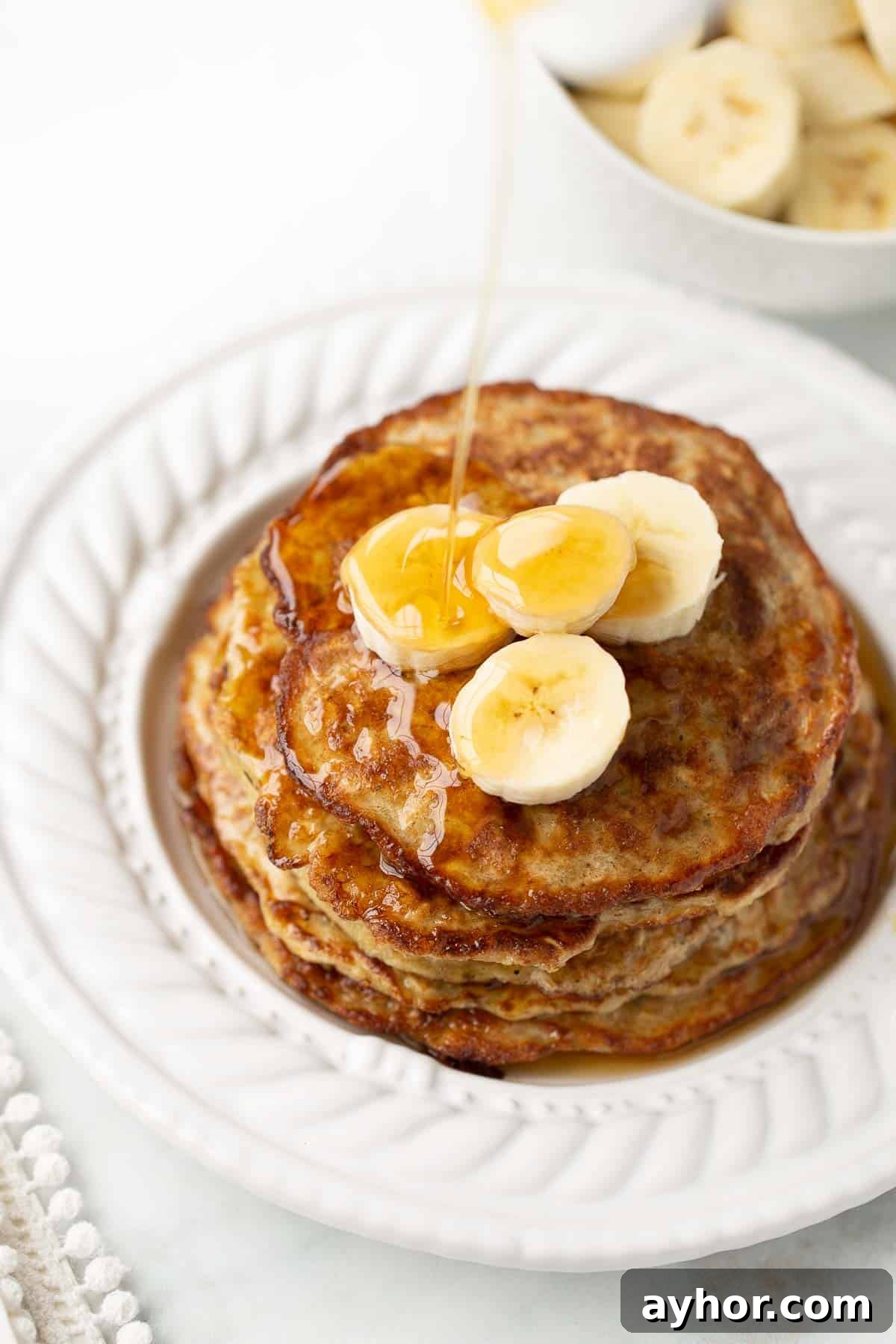 syrup poured on banana oatmeal pancakes