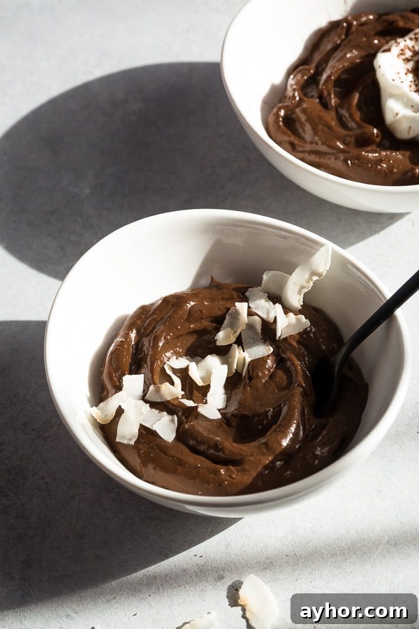 Silky Avocado Chocolate Mousse Recipe 5 Mousse topped with fresh berries and a sprinkle of coconut chips