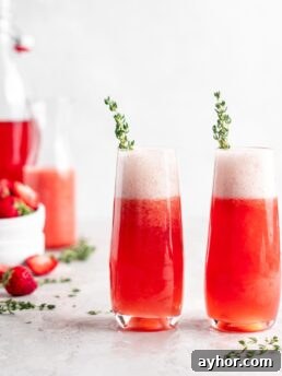 Bright red strawberry guava juice is mixed with sparkling rose wine in stemless champagne glasses to make Strawberry Guava Mimosa