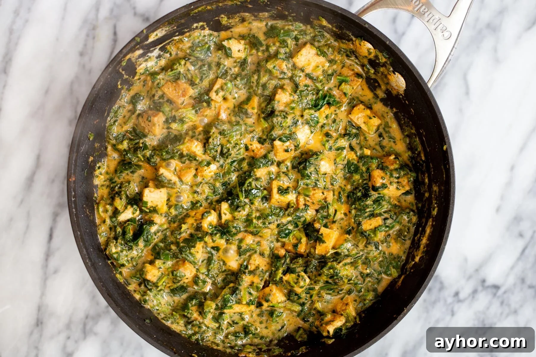 tofu in a skillet in creamy spinach gravy