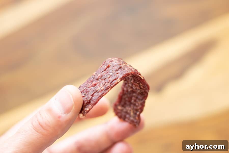 Coconut-Infused Ground Beef Jerky 10 ground beef jerky strip being bent in half