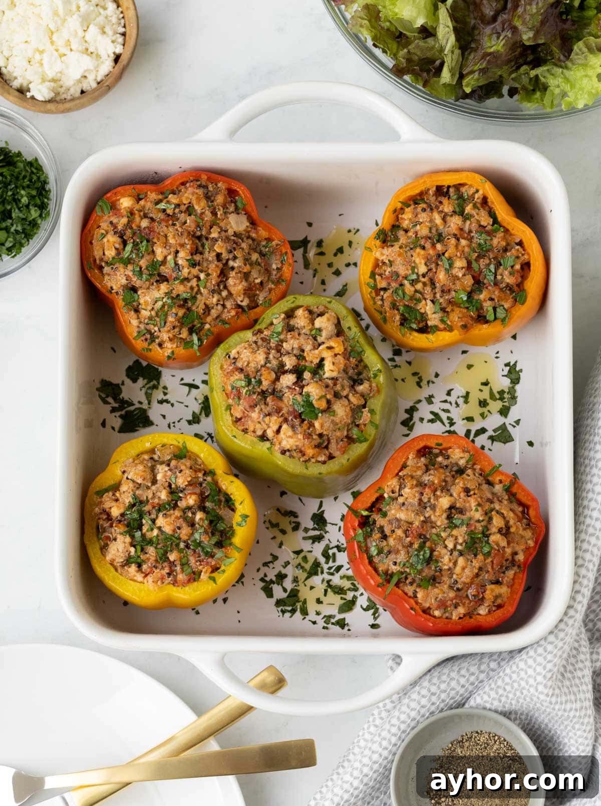 Ground Turkey Stuffed Peppers with Savory Tomato Rice 2 Red, yellow, green, and orange stuffed peppers in a white baking dish.