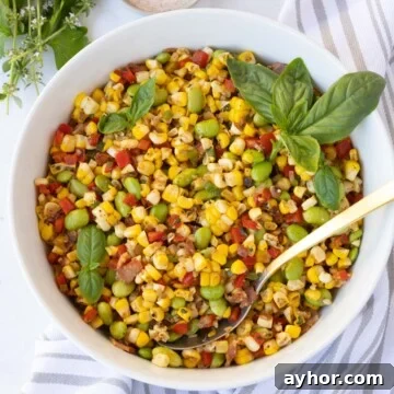 Closeup of corn succotash with red and green peppers and bacon.