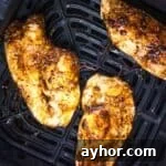 Juicy thin chicken breast in the air fryer basket.