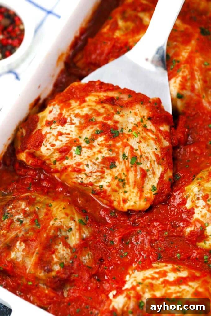 Comforting Stuffed Cabbage Rolls with Savory Tomato Sauce 13 stuffed cabbage rolls in tomato sauce in a baking dish
