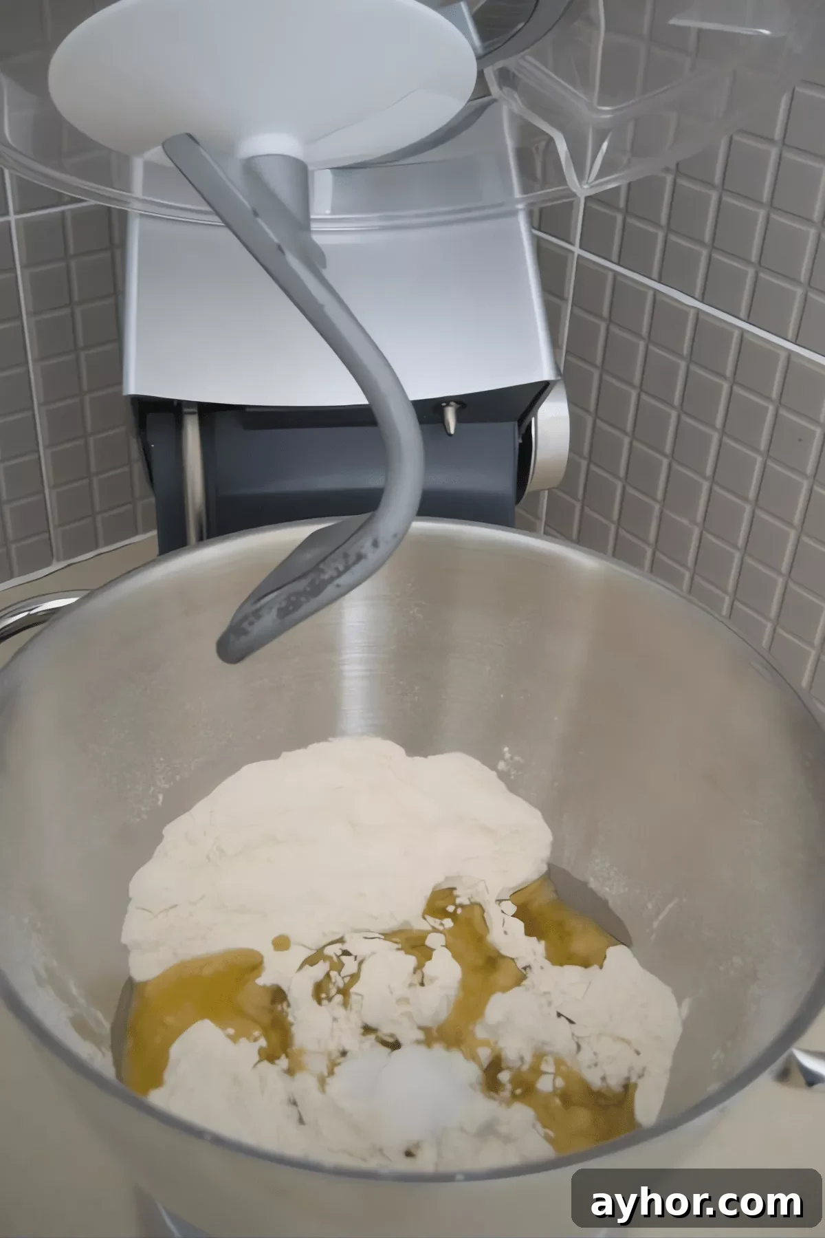 How to Make Homemade Pizza Dough from Scratch 3 Homemade pizza dough ingredients in a mixer bowl with flour, salt and olive oil.