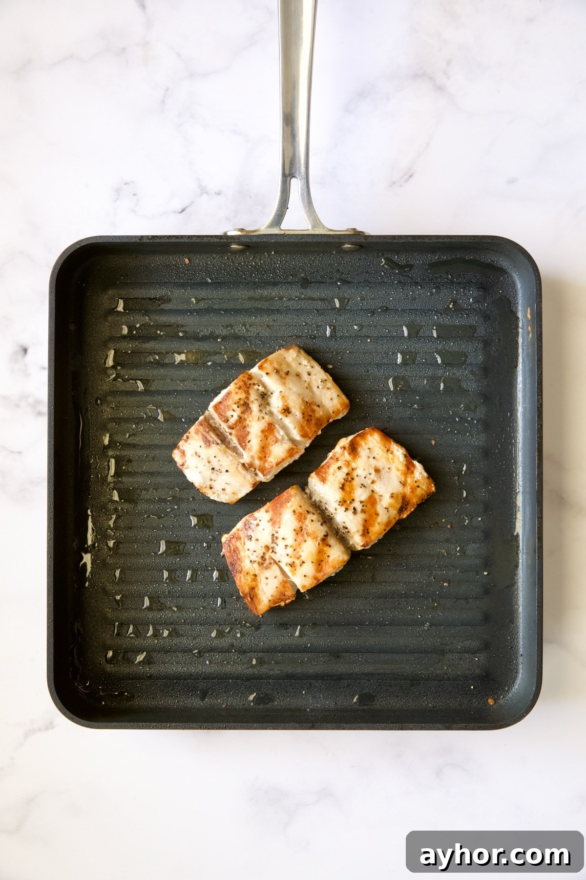 Grilled Mahi Mahi with Cilantro-Ginger Pesto Recipe 9 Two pieces of mahi-mahi on nonstick grill pan after being grilled.