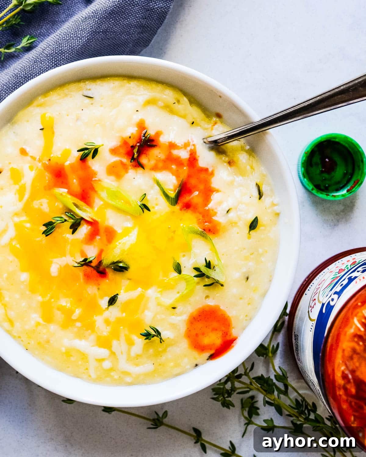 Creamy Roasted Garlic Grits with Melted Cheese 8 Adding hot sauce to the cheese grits.