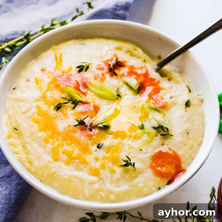 A bowl of cheese grits with hot sauce.