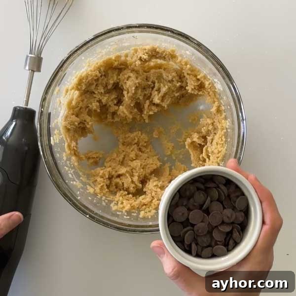 Adding the chocolate chips to the cookie dough.