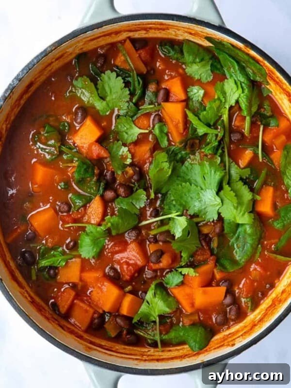 Sweet Potato and Black Bean Stew served in a large pot topped with coriander.