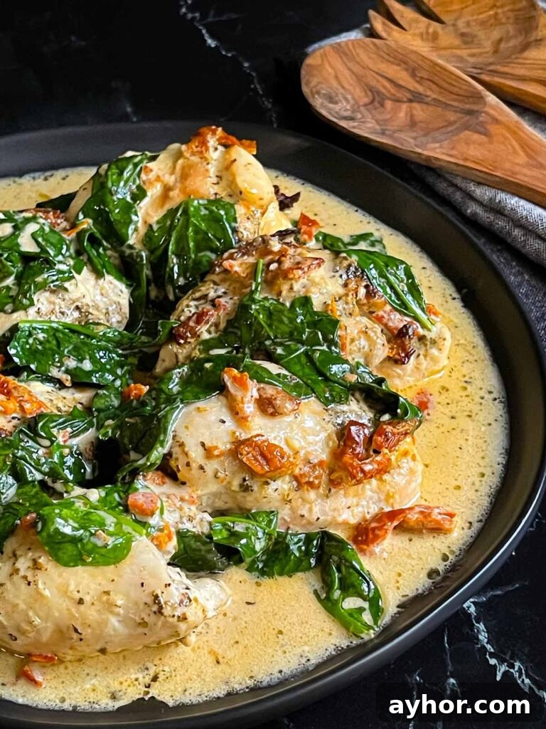 Slow Cooker Tuscan Chicken in a dark bowl on a dark surface.