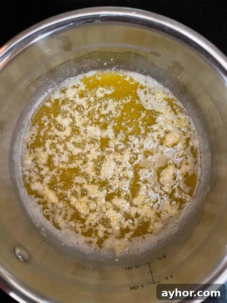 Butter with herbs with garlic just added in a sauce pan.