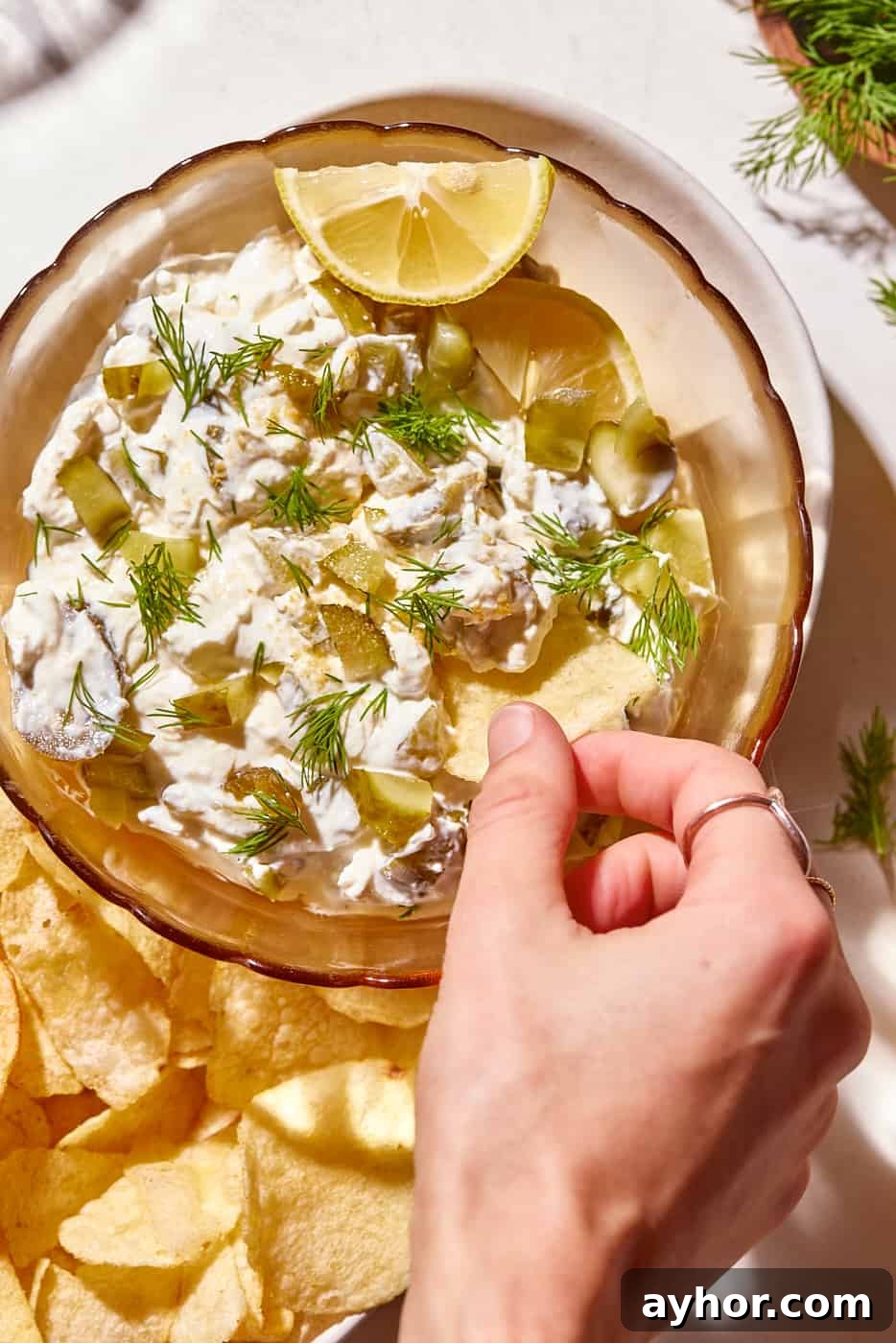 pickle dip in bowl and dipping a chip