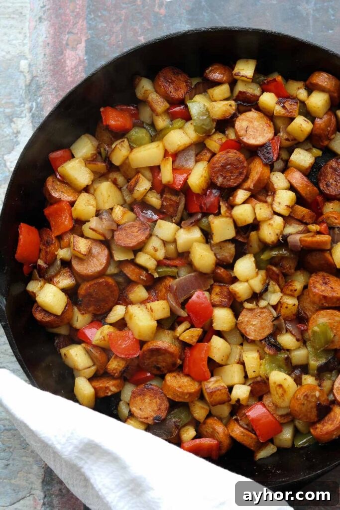 Cajun Potato Hash with Sausage and Peppers 2 cajun spiced potato hash with sausage in skillet
