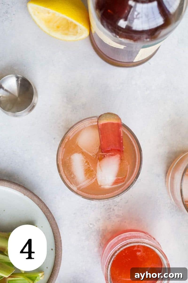 Rhubarb Bourbon Sour: Spring Cocktail Recipe with Rye Twist 7 A bourbon sour cocktail in a glass with ice.