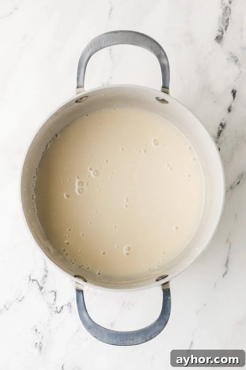 Mango Sticky Rice with Coconut Cream: Authentic Thai Dessert Recipe 11 Sweet coconut sauce simmering in a pot for mango sticky rice.