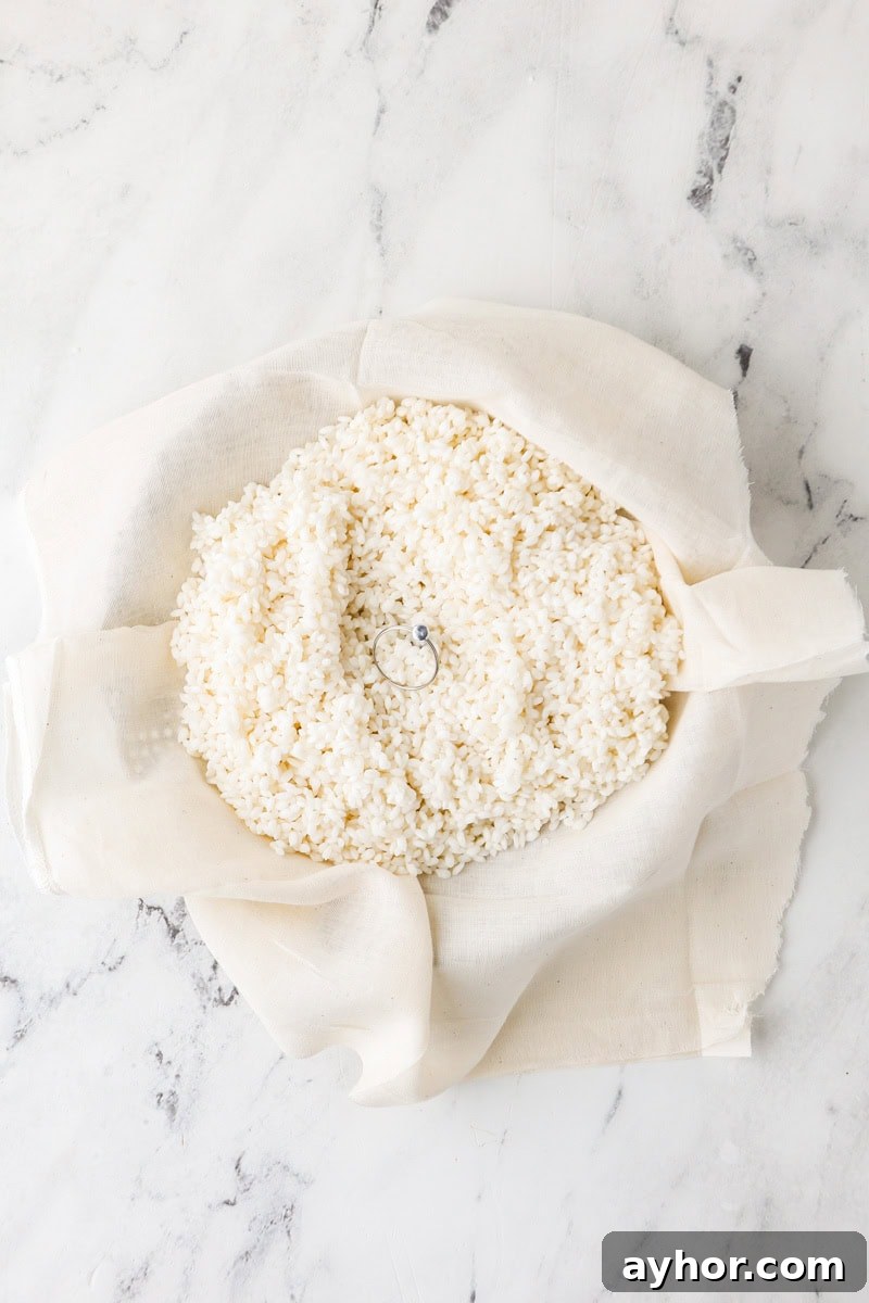 Mango Sticky Rice with Coconut Cream: Authentic Thai Dessert Recipe 7 Soaked sticky rice spread on cheesecloth inside a steamer basket.