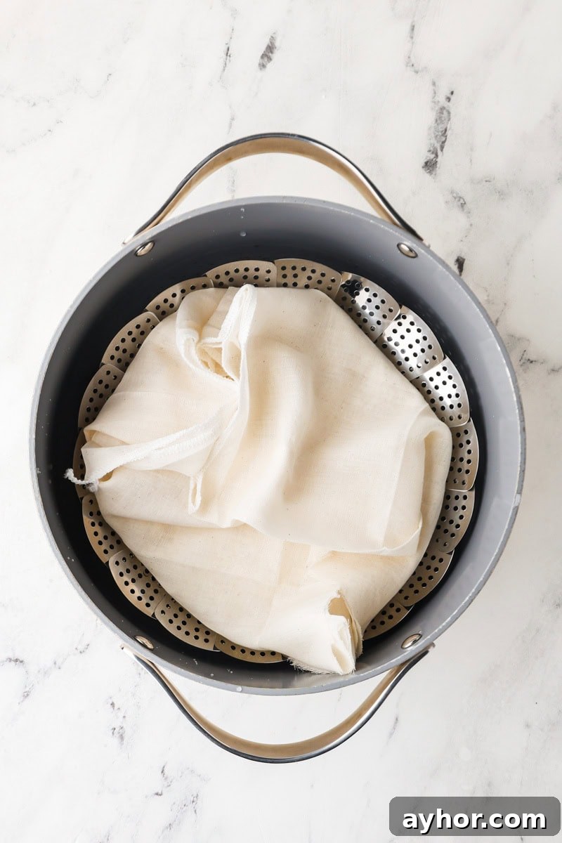 Mango Sticky Rice with Coconut Cream: Authentic Thai Dessert Recipe 8 Sticky rice steaming in a metal basket over simmering water.