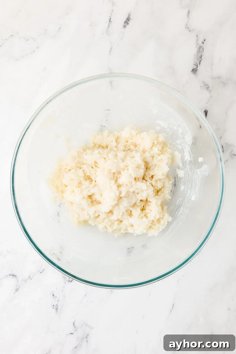 Mango Sticky Rice with Coconut Cream: Authentic Thai Dessert Recipe 10 Cooked sticky rice in a bowl with coconut cream sauce.