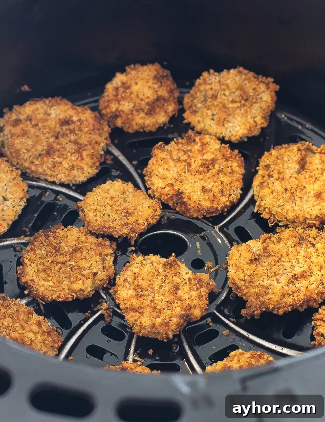 Crispy Air-Fryer Pickles: Tangy Homemade Fried Pickle Chips 3 Fried pickles in the insert of an air fryer.