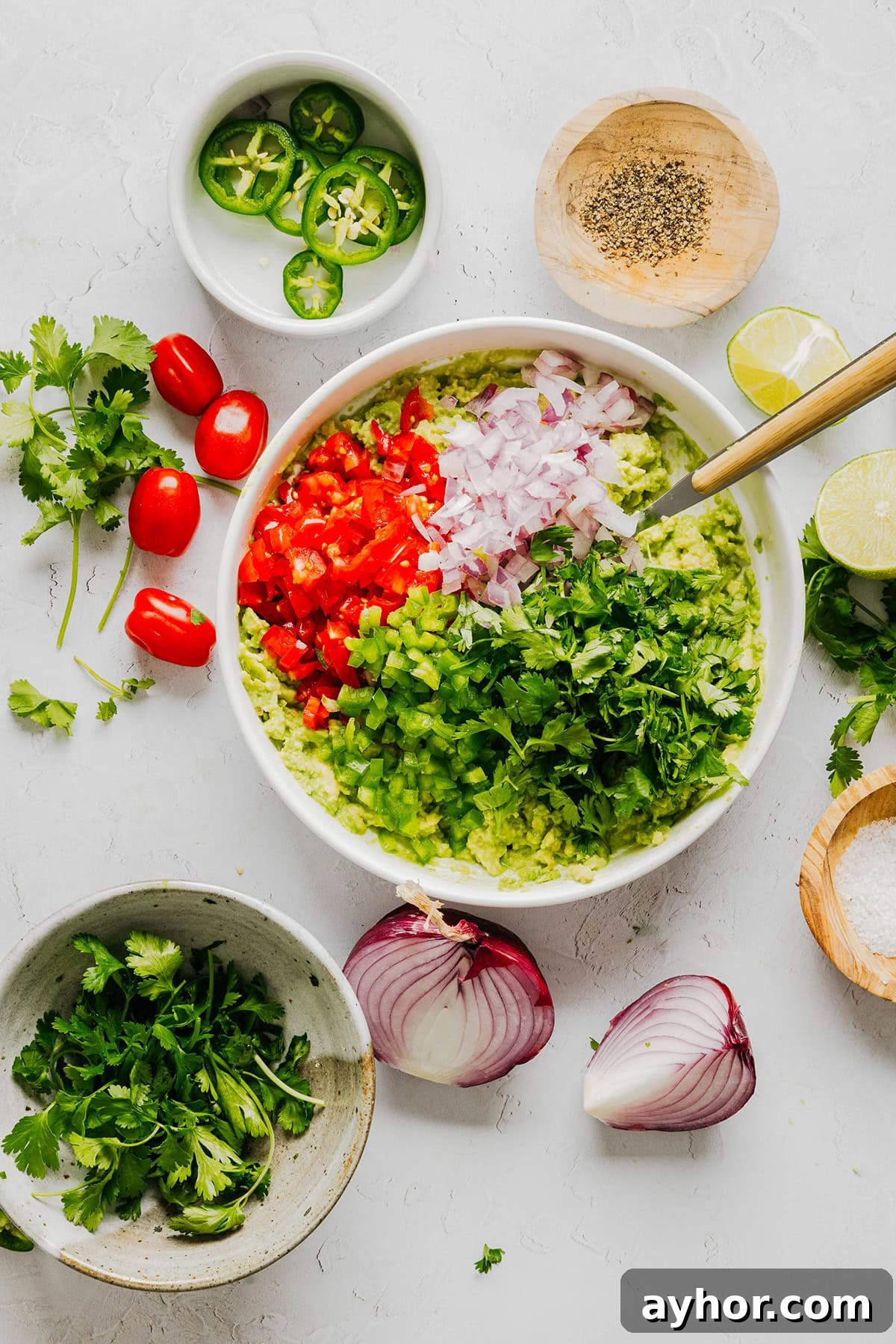 The BEST Chunky Guacamole recipe made with ripe avocados, crisp veggies, zesty lime juice and a kick of heat that you can easily throw together in just minutes! Perfect for summer barbecues, game day parties, taco nights or simply craving a fresh snack.
