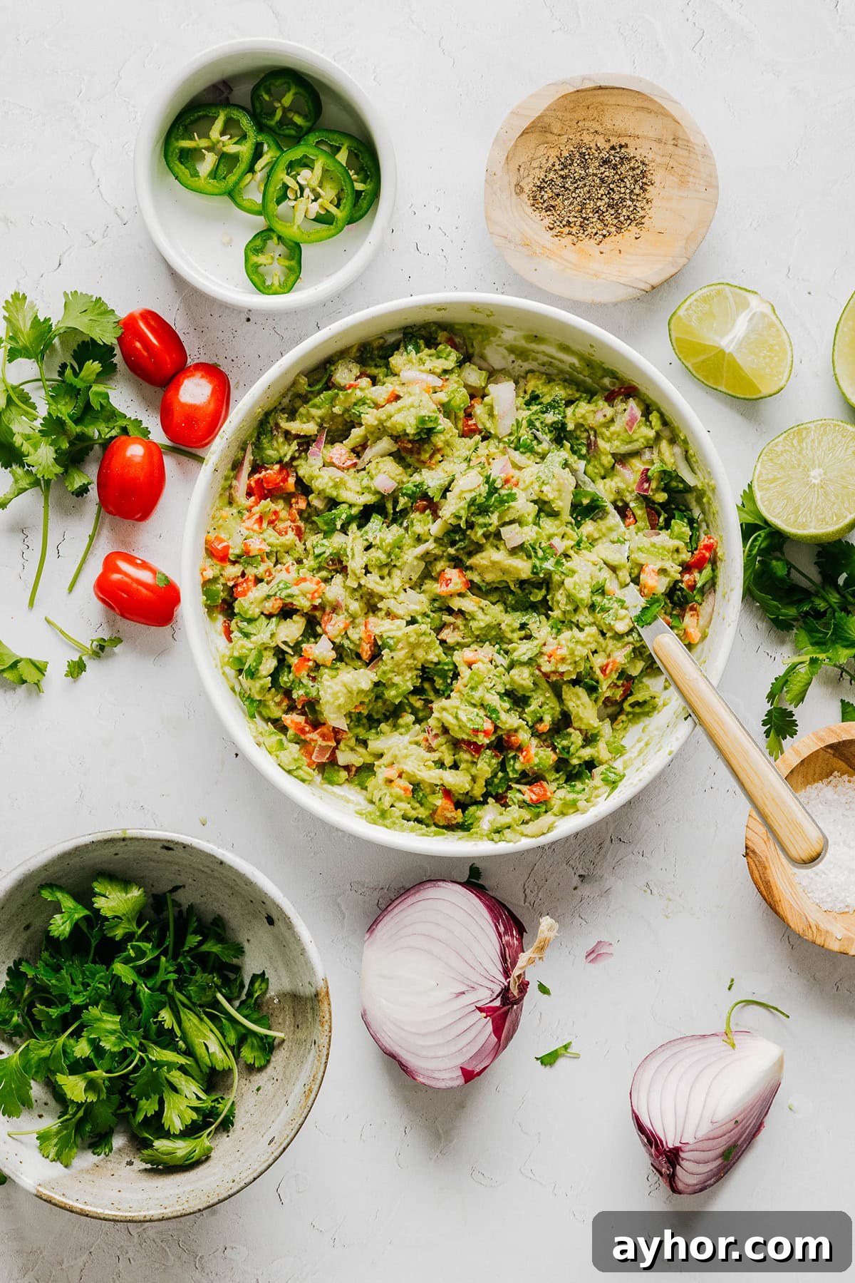 The BEST Chunky Guacamole recipe made with ripe avocados, crisp veggies, zesty lime juice and a kick of heat that you can easily throw together in just minutes! Perfect for summer barbecues, game day parties, taco nights or simply craving a fresh snack.