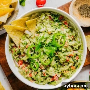The BEST Chunky Guacamole recipe made with ripe avocados, crisp veggies, zesty lime juice and a kick of heat that you can easily throw together in just minutes! Perfect for summer barbecues, game day parties, taco nights or simply craving a fresh snack.