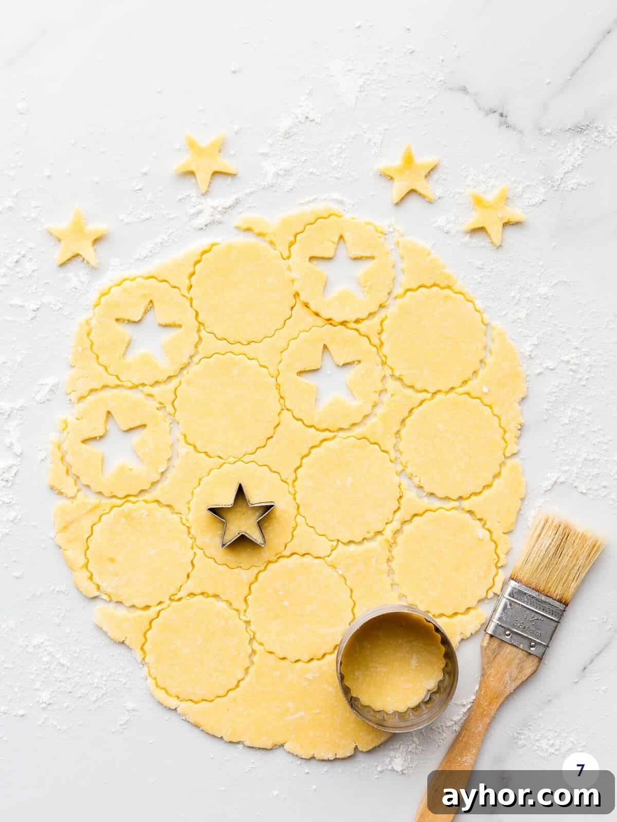 Cutting out cookies with cookie cutters to make lemon curd linzer cookies.