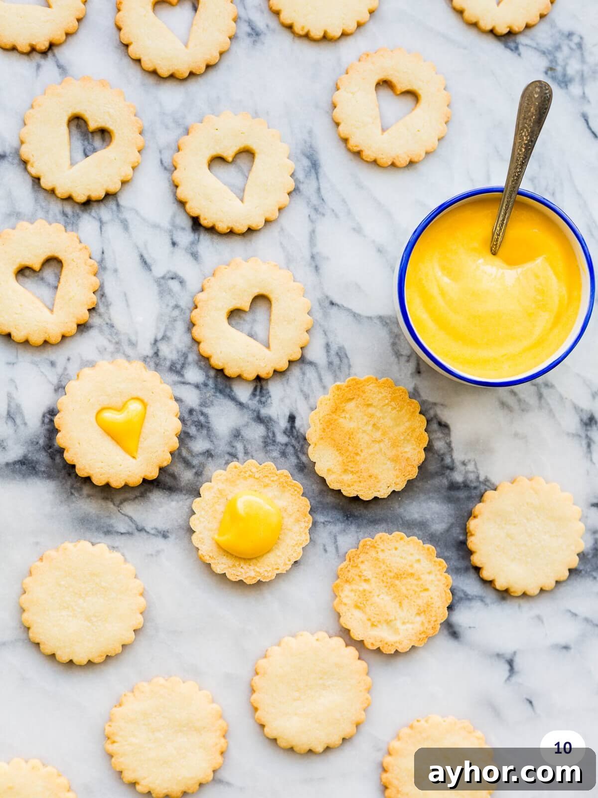 Topping coconut shortbread cookies with lemon curd before sandwiching them together.