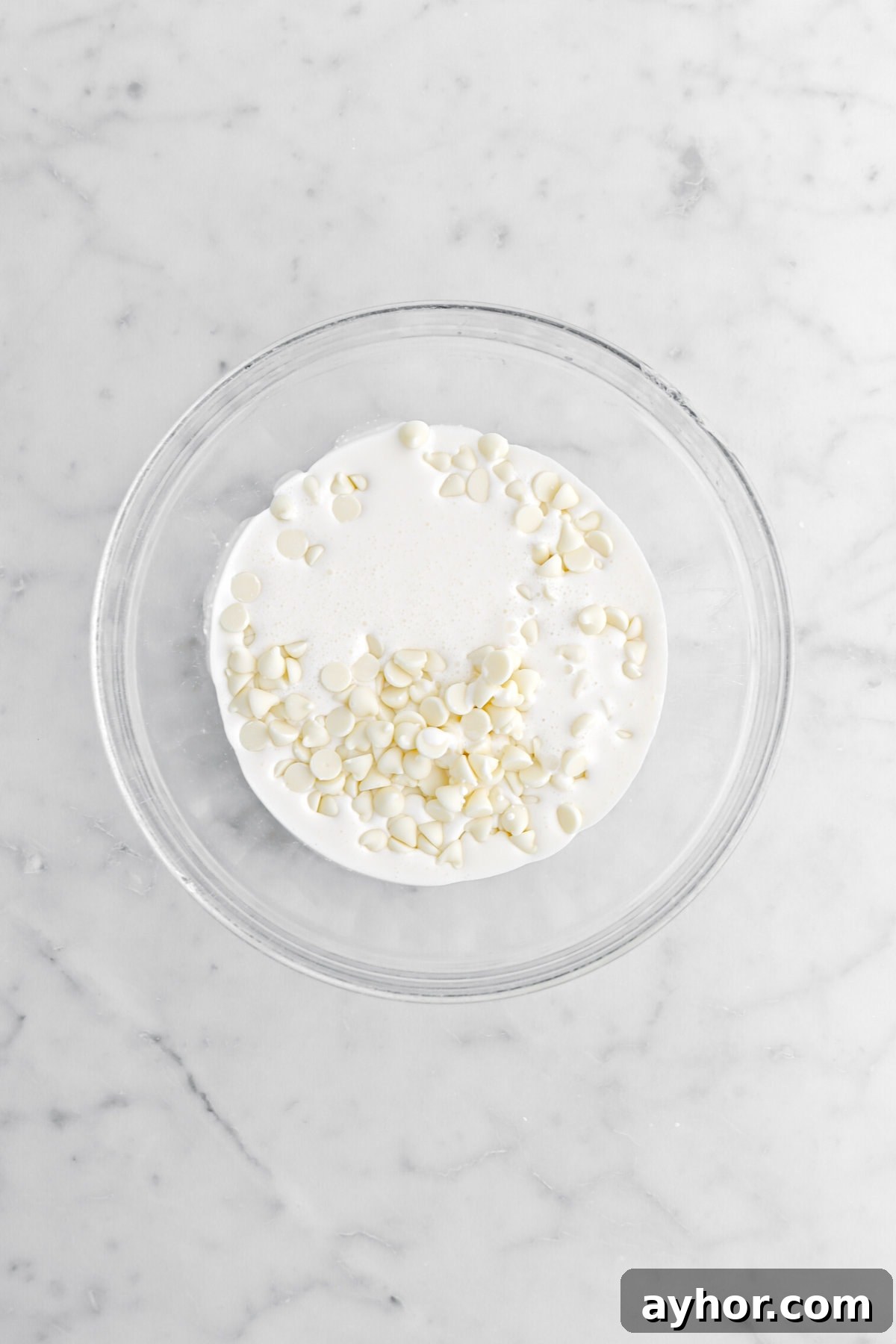 cream and white chocolate chips in glass bowl.