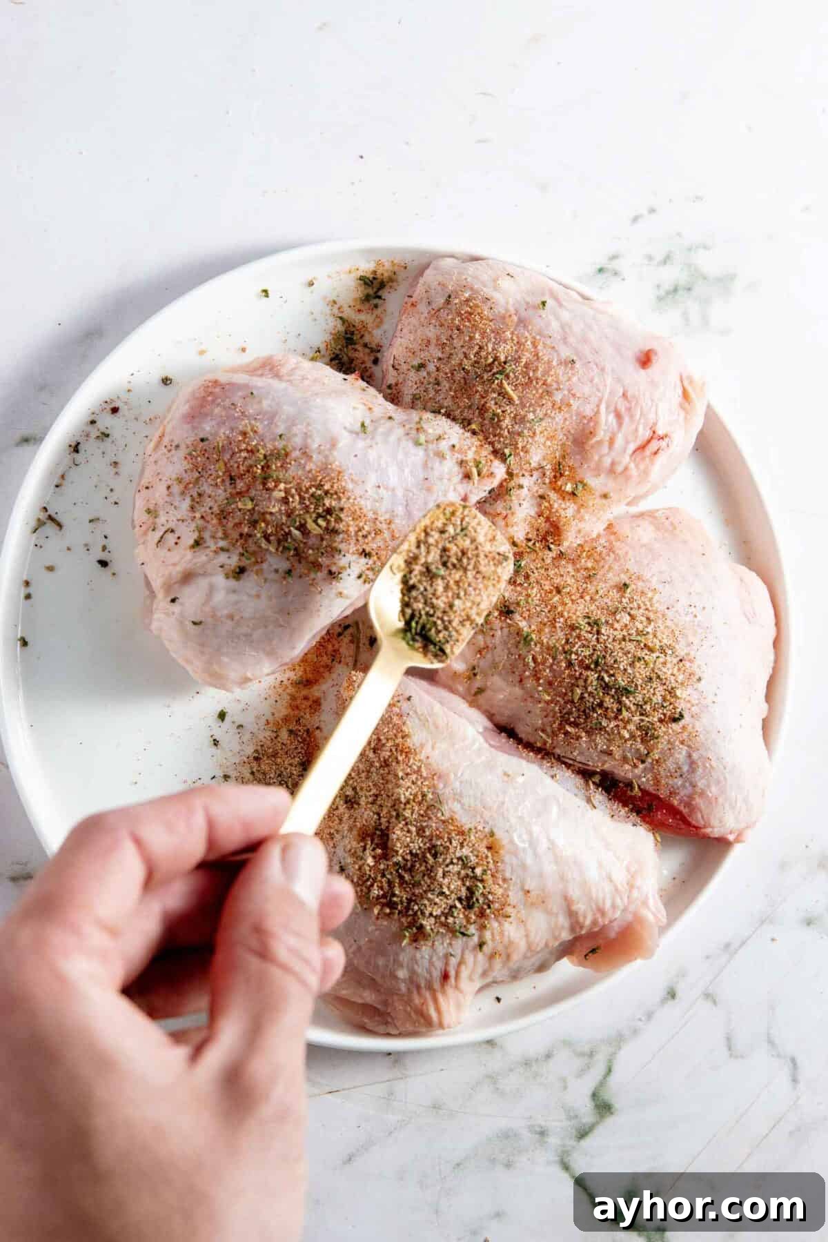 Sprinkling spices on thighs.