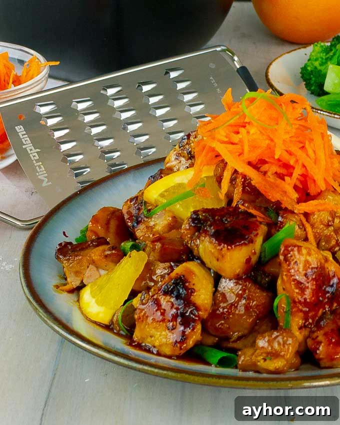plate of Sticky Orange Chicken Recipe with a carrot garnish