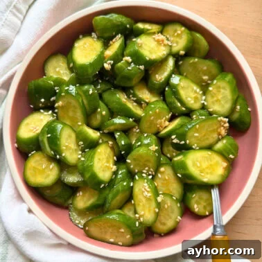 Quick Garlic Toast Recipe for Crispy, Flavorful Slices 14 Freshly sliced cucumbers topped with sesame seeds in a pink bowl, set against a neutral background.