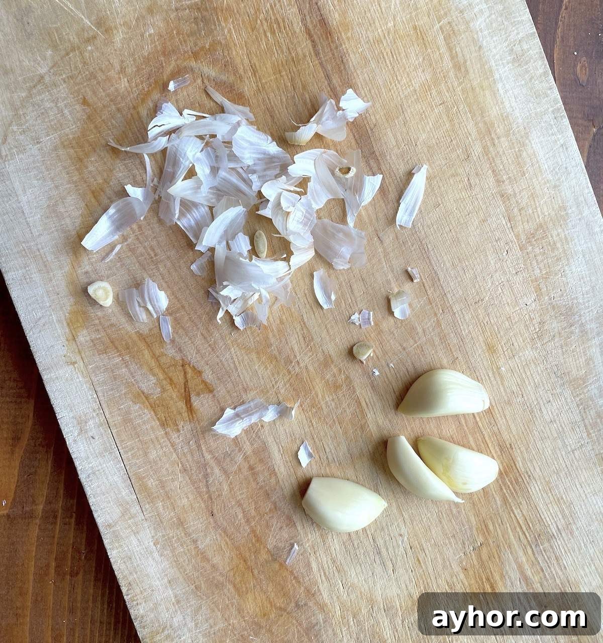 Quick Garlic Toast Recipe for Crispy, Flavorful Slices 4 Peeled garlic on a wooden board.