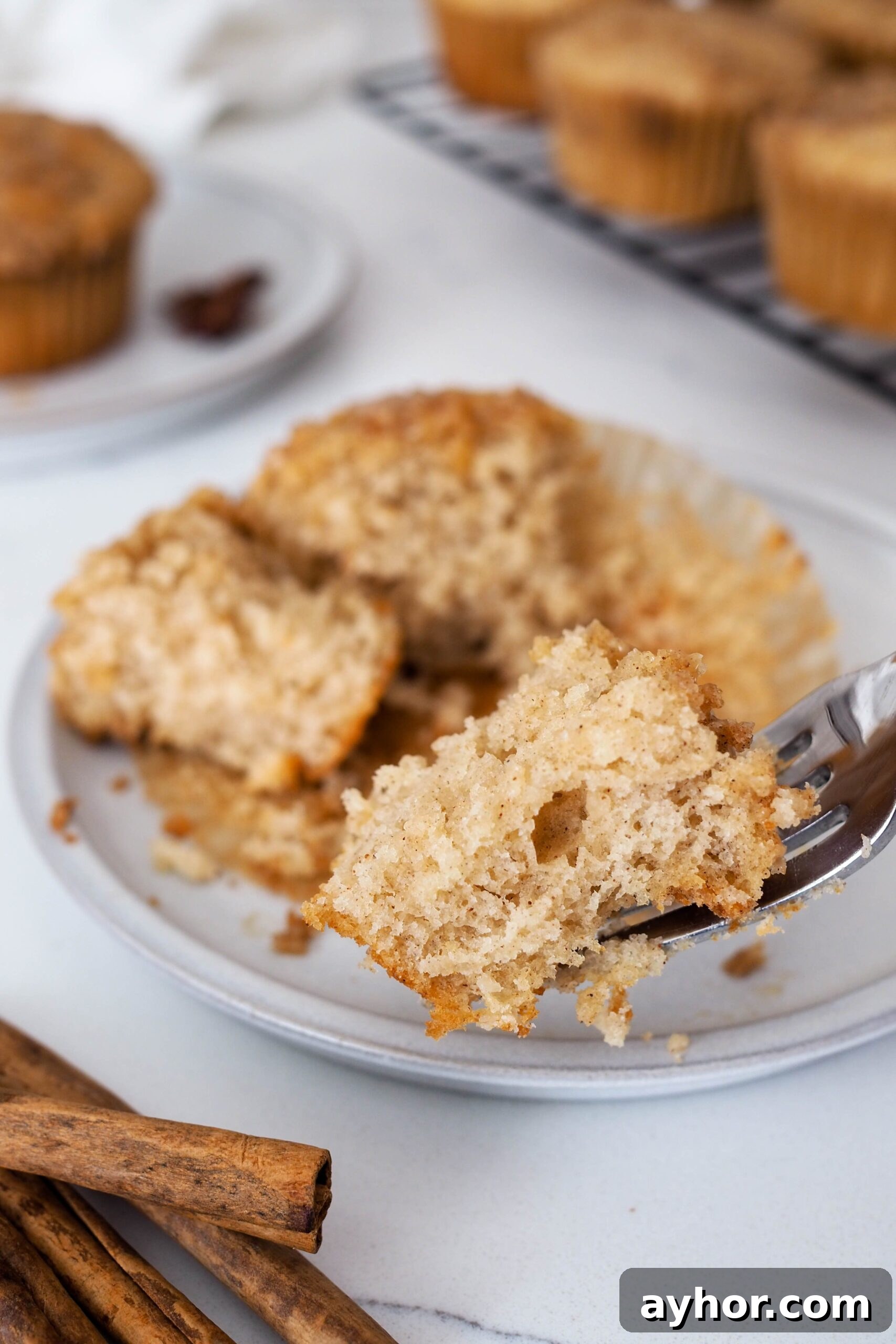 Caramel Chai Muffins Recipe — Warm Spiced Muffins with Caramel 2 A bite of caramel chai muffin held up close to the camera with a fork.