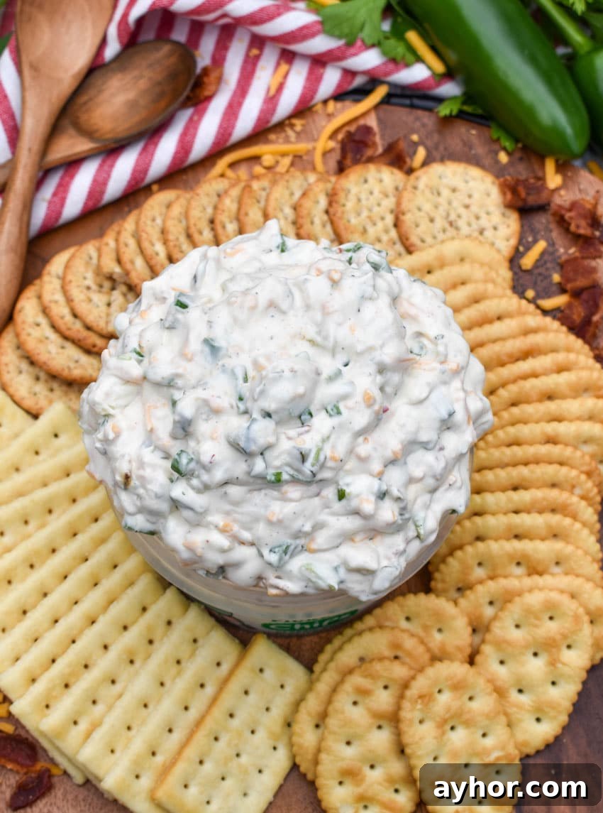a plastic tub filled with grillo's dill pickle dip surrounded by crackers