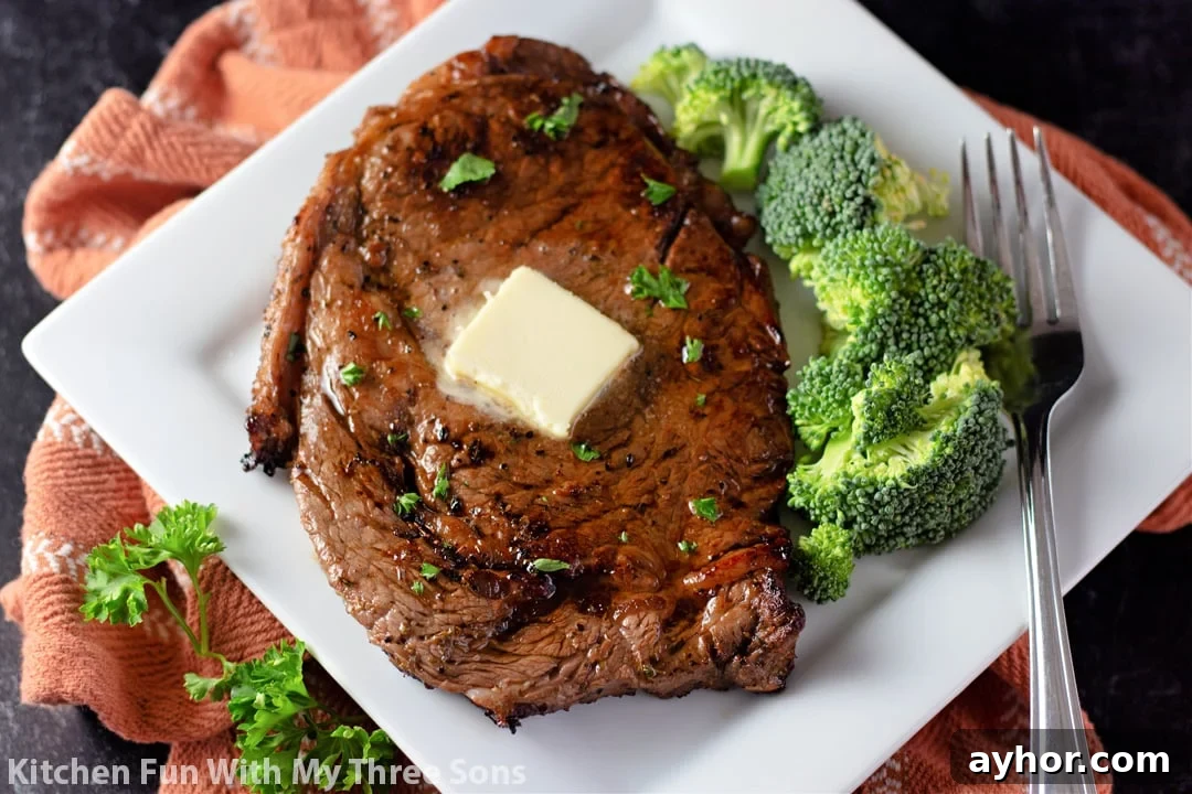 A steak and broccoli on a white plate with a brown napkin.