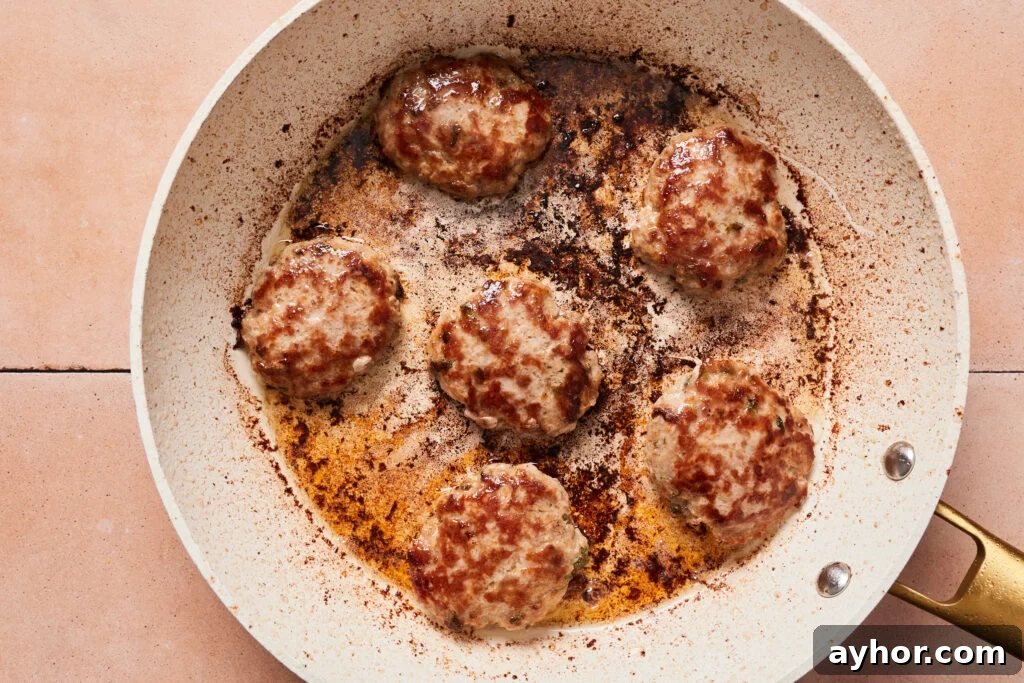 Pork sausage patties pan fried in a skillet