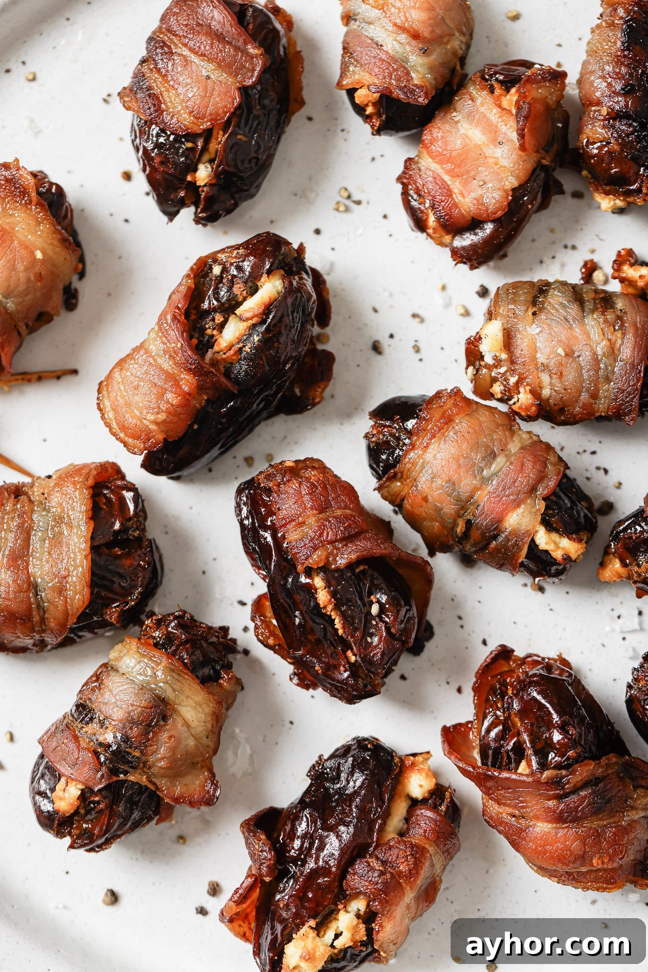 Bacon-Wrapped Dates: Sweet and Savory Appetizer Recipe 2 Close up of bacon-wrapped dates on a white plate.
