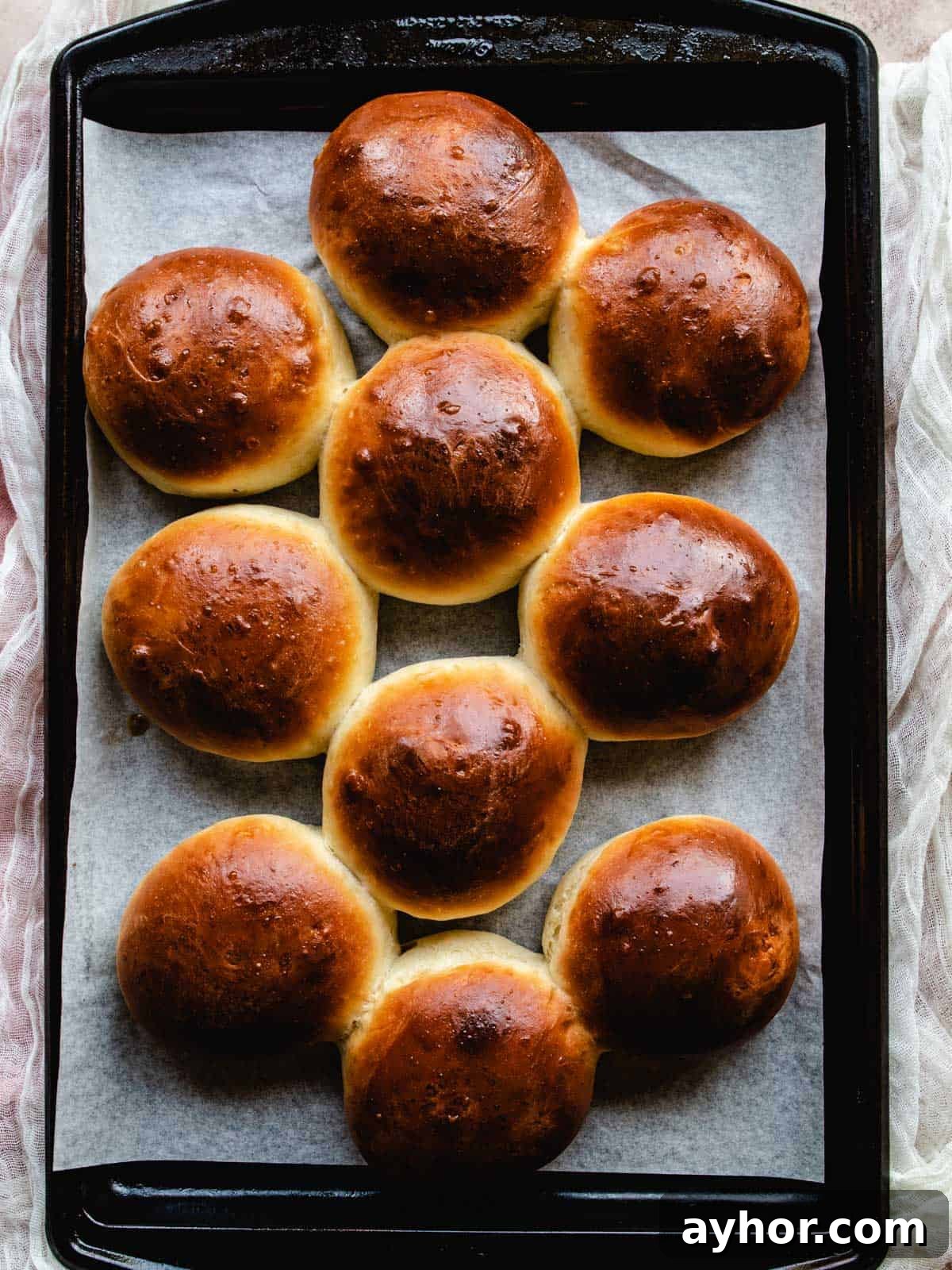 freshly baked brioche buns on a tray
