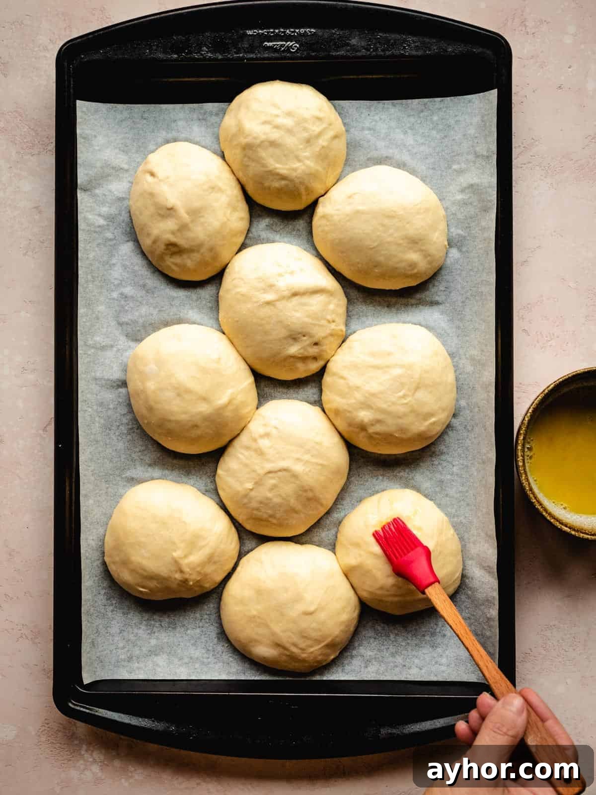 brushing brioche buns with egg wash