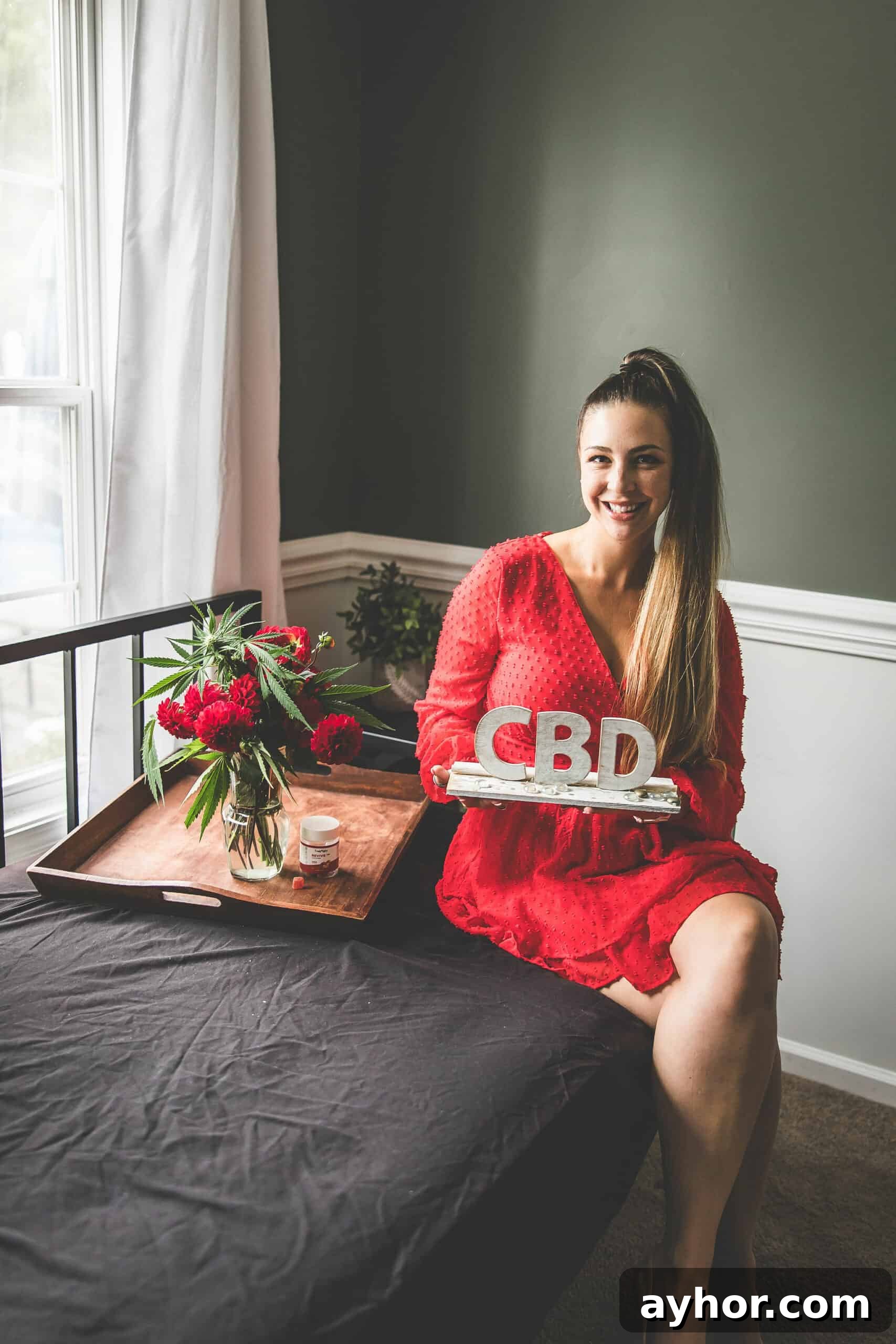 CBD for Wellness: A Complete Guide to Uses, Benefits, and Dosage 6 A picture of Emily Kyle holding a CBD sign.
