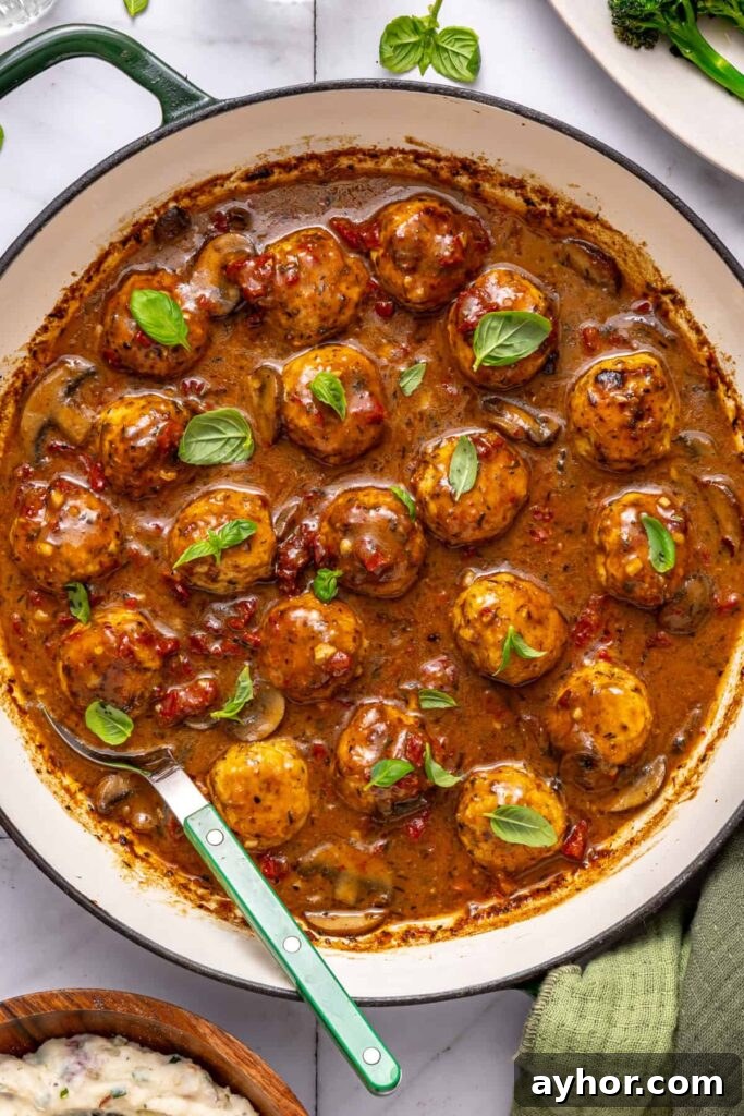 One-pan chicken meatballs topped with fresh basil in skillet
