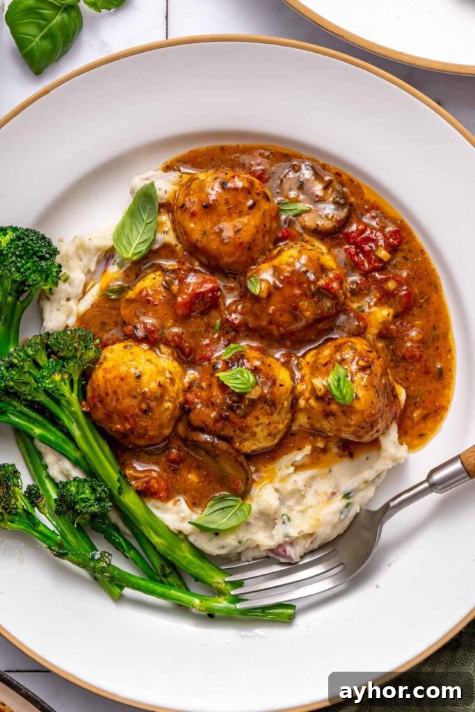 Plated marry me chicken meatballs dinner with rice and greens