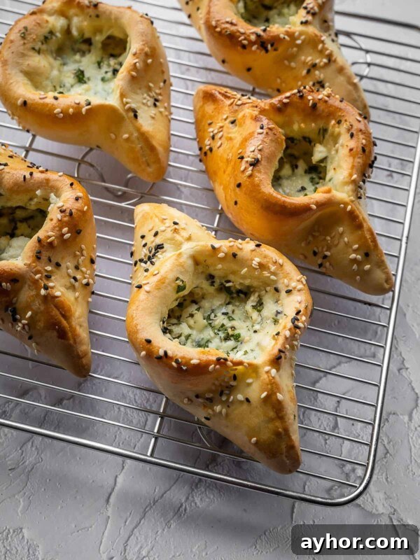 Levantine Ful Medames: Classic Chickpea & Fava Bean Stew Recipe 12 Cheese and herb fatayer pastries with sesame seeds on a cooling rack.