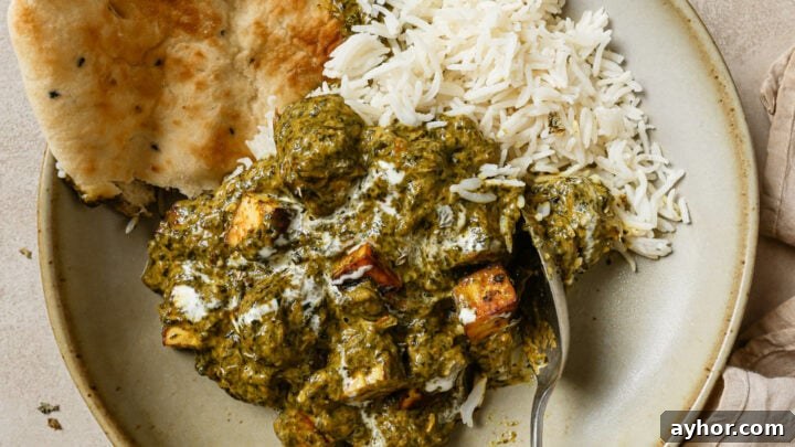 Palak Paneer in a bowl with naan and rice