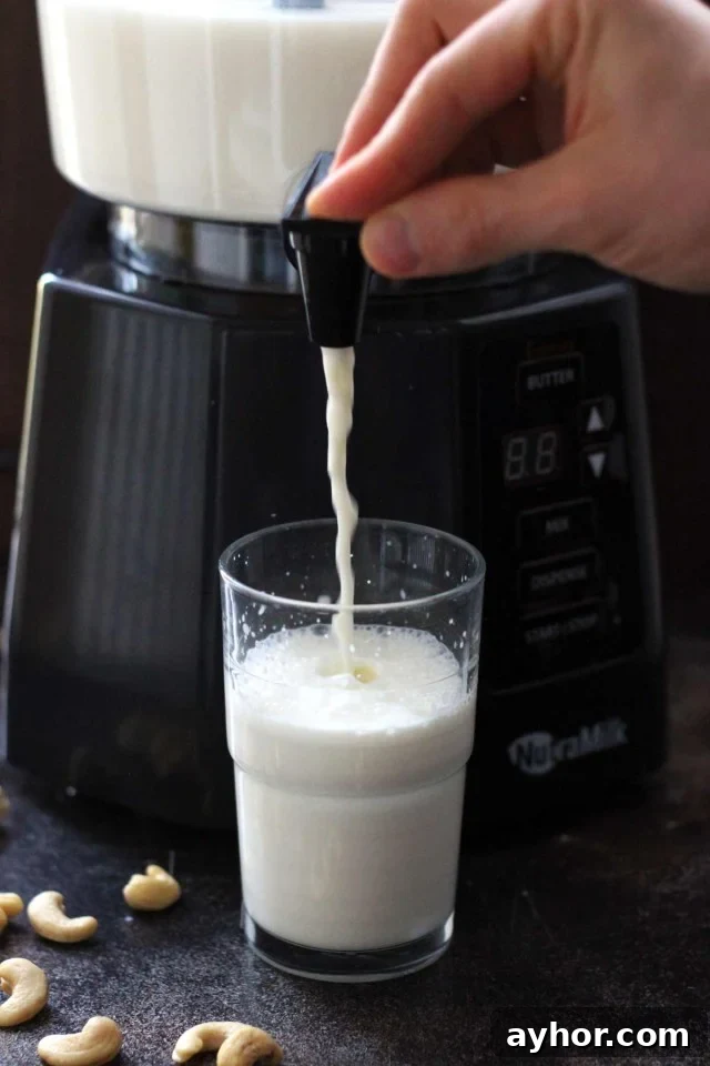 Healthy Vegan Pumpkin Spice Latte - the NutraMilk Dispensing Nut Milk in a Glass Closeup with the Glass Half-Filled